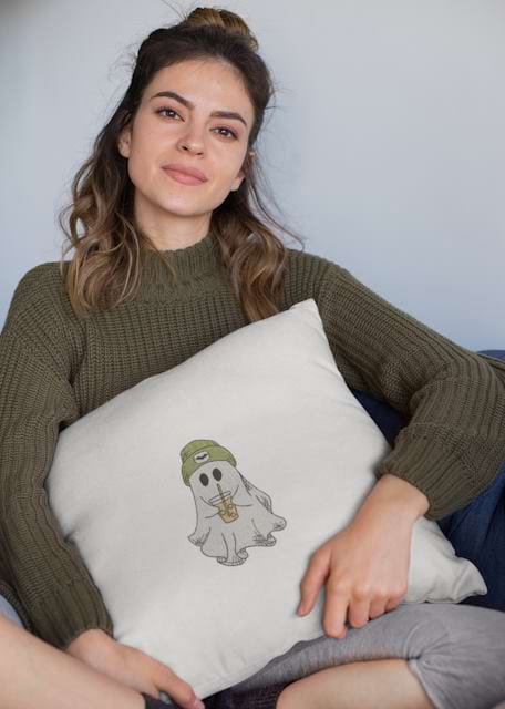 woman holding a square pillow with ghost embroidery design