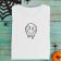 folded t-shirt with Drippy smiley free embroidery design featuring halloween decorations