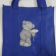Teddy bear with chamomile design on embroidered blue bag