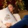 woman hugging a pillow with christmas highland bull embroidery design