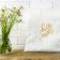 square pillow with happy easter free embroidery design placed next to flower vase