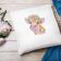 pillow with cow embroidery design featuring decorative flowers and wooden surface