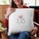 mockup smiling woman holding a pillow with tohether love embroidery design