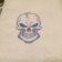 Embroidered smiling skull on white towel