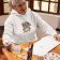Embroidered pullover hoodie mockup featuring a senior woman painting at home