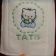 White bath towel with embroidered Hello Kitty baby bib design on it